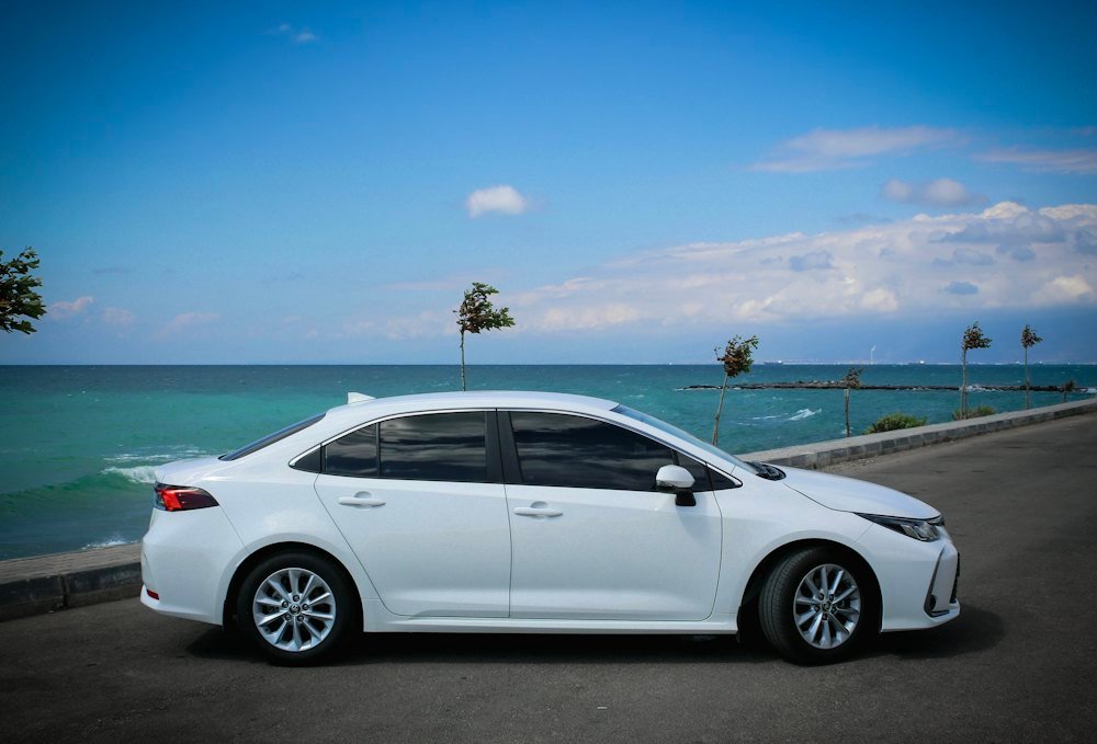 Clean white sedan on a coastal road
